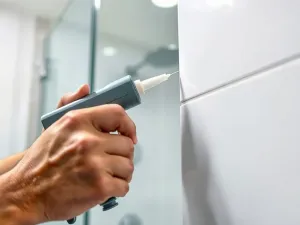 Świeże maliny na drewnianym stole w otoczeniu próbek tkanin w odcieniach różu, magenty i głębokiej czerwieni.